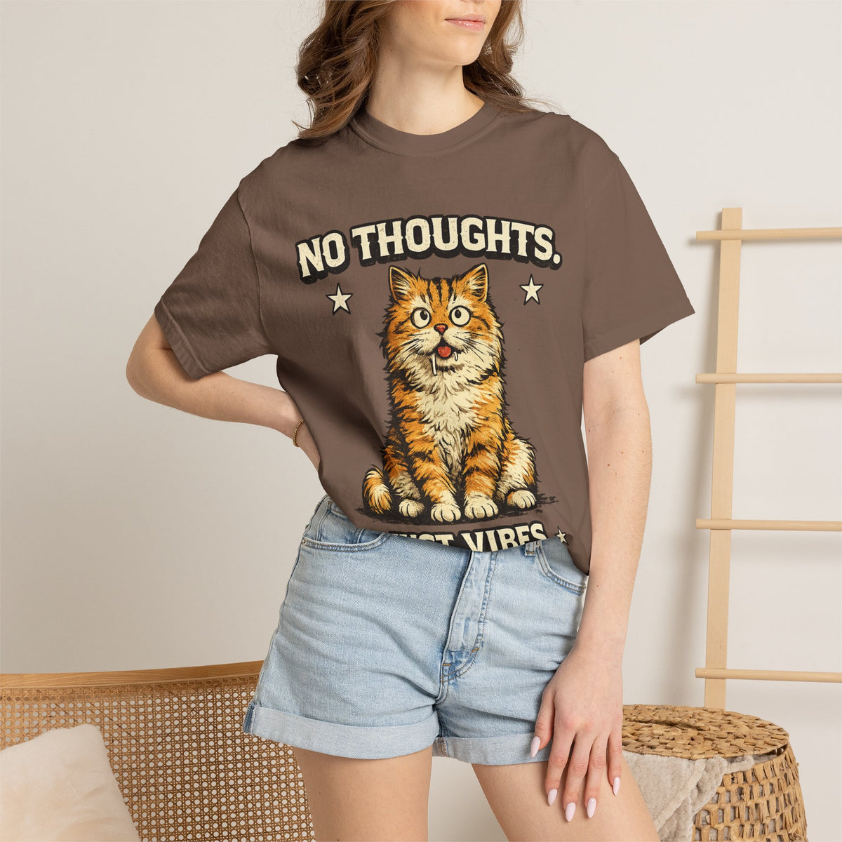 Funny orange cat graphic printed on a black unisex t-shirt with the quote "No Thoughts Just Vibes" for cat lovers and streetwear fashion.